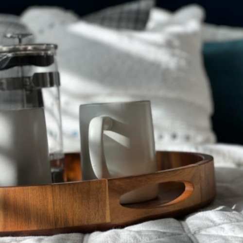 a bed with a tray with drinks