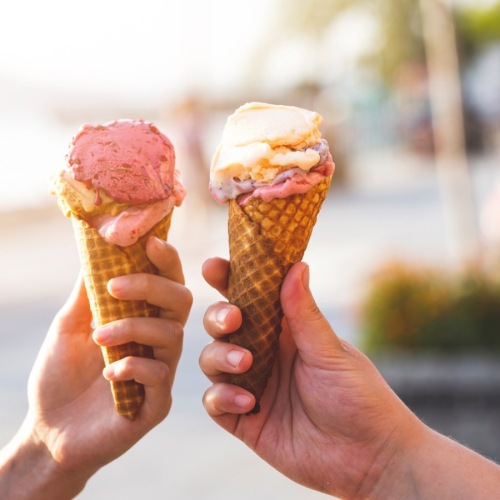 a group of hands holding ice cream cones