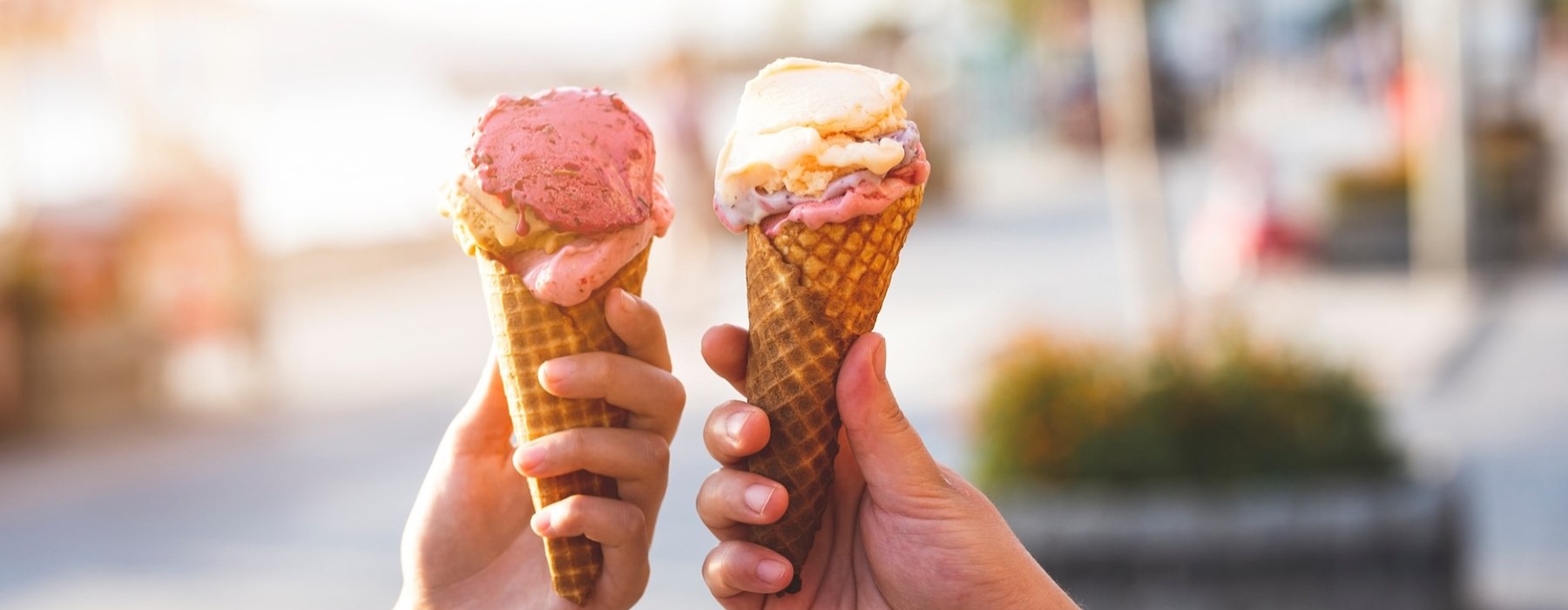 a group of hands holding ice cream cones