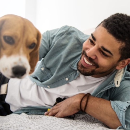 a man laying on a bed with a dog